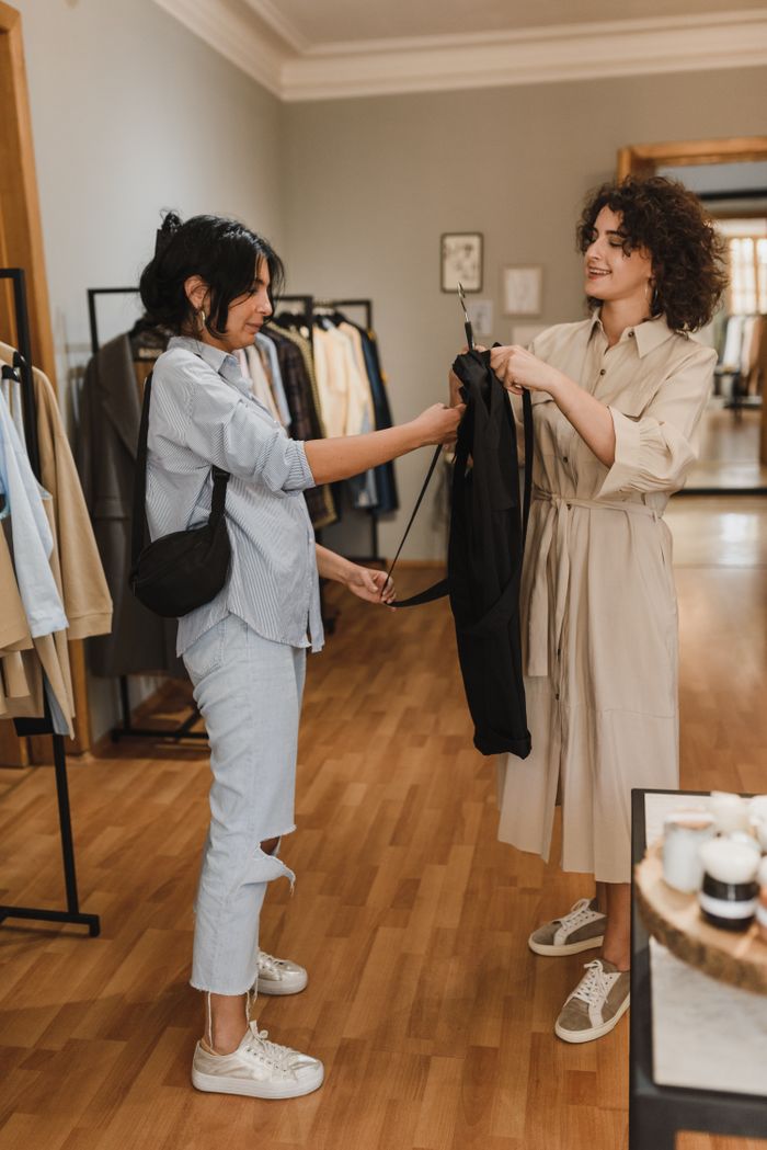 Crafting Captivating Headlines: Your awesome post title goes here Women enjoying a shopping experience in a boutique, trying on clothes and smiling.